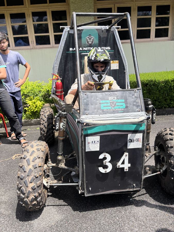 A helmeted driver sitting in the car, viewed head-on