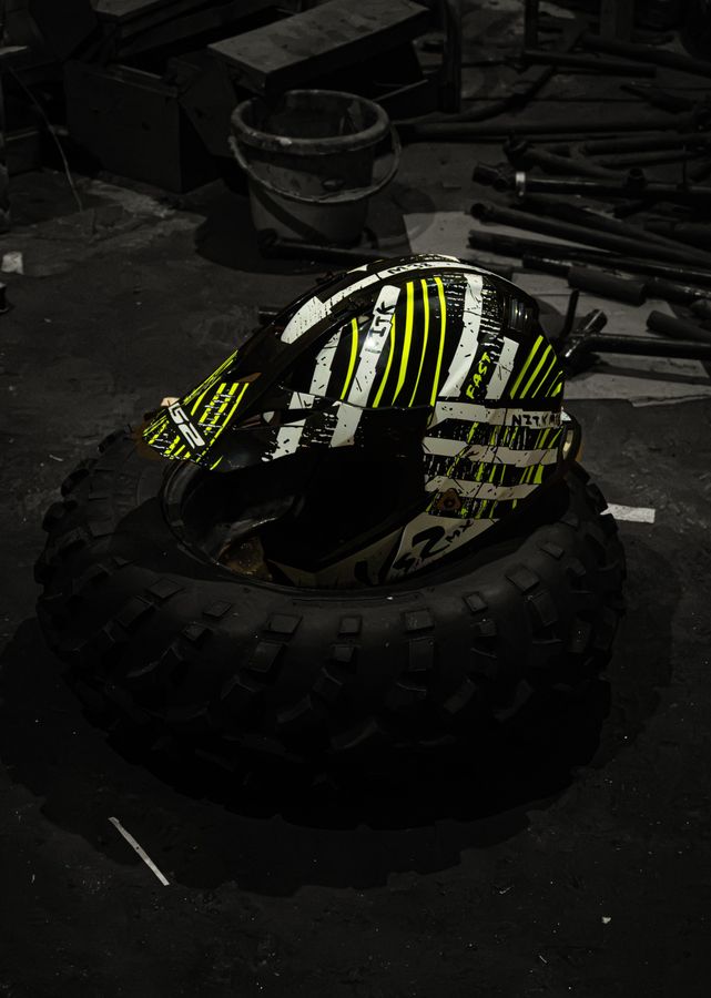 The neon-yellow helmet sitting in a knobbly tyre on the workshop floor