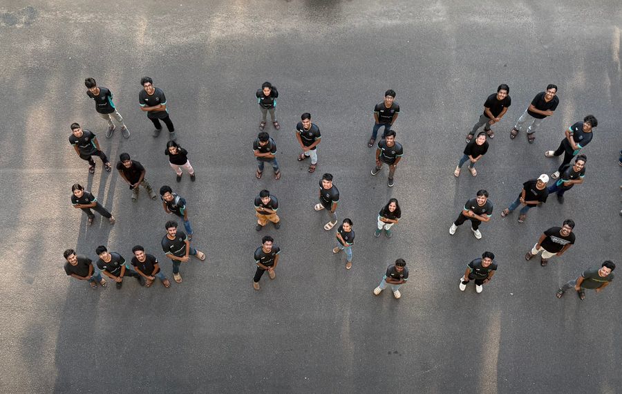 Top-down photo of team members standing in formation on concrete