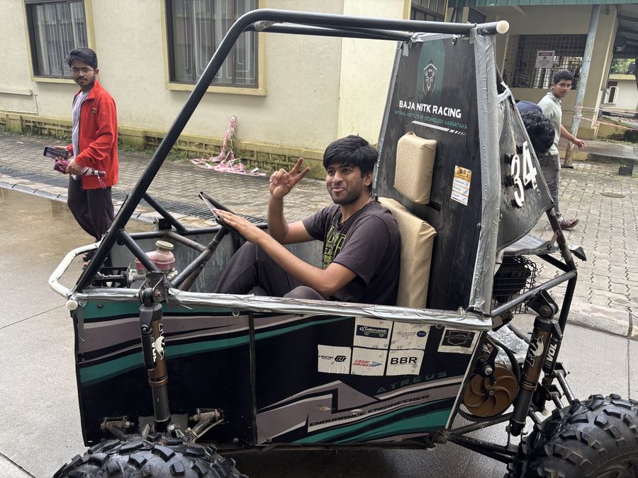 A smiling team member waving from the driver’s seat