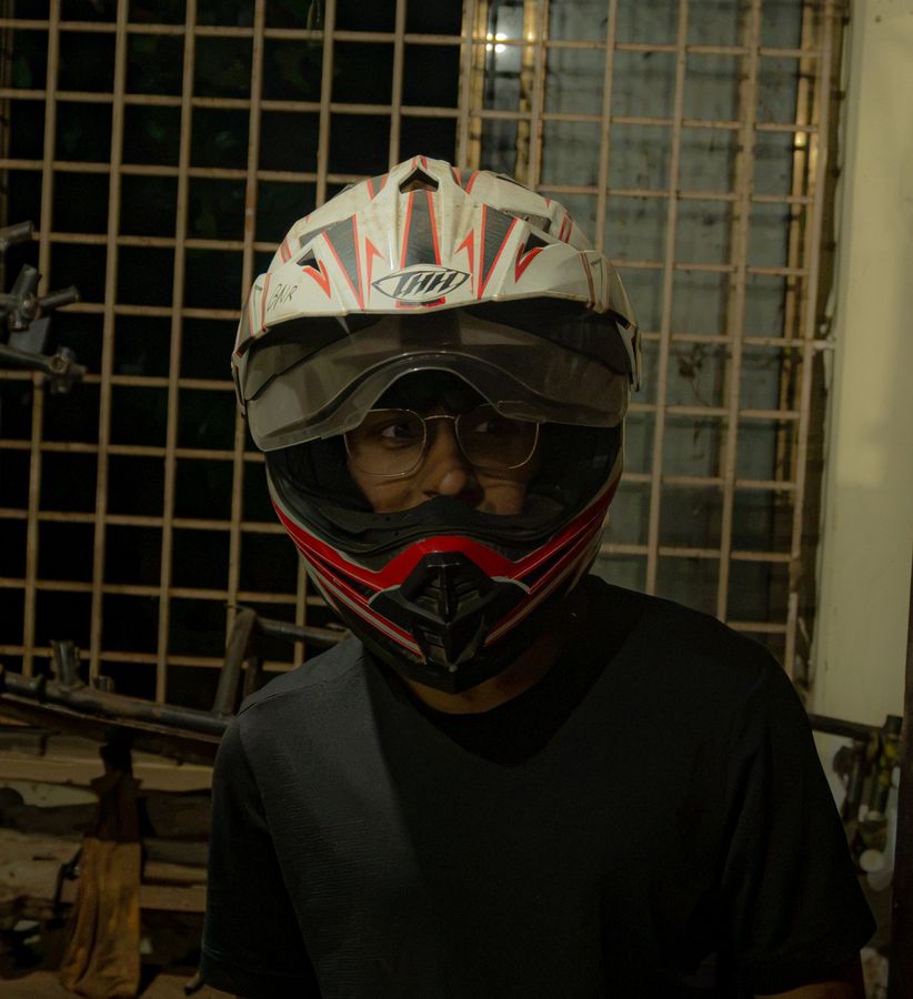 A team member in a white and red off-road helmet looking sideways