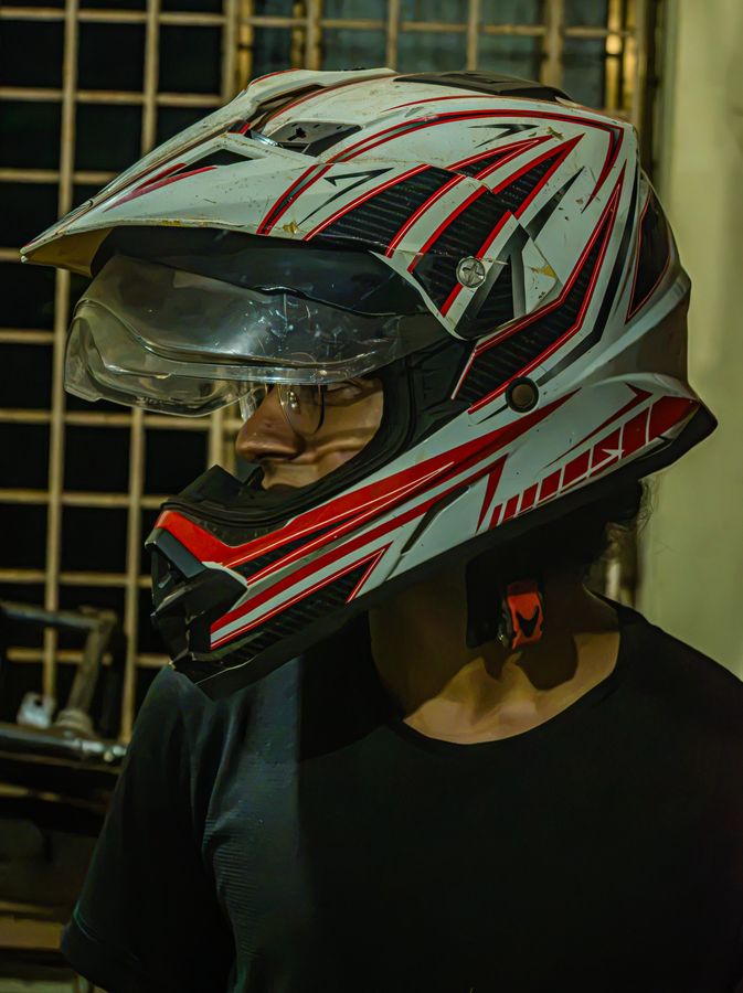 Side profile of a team member wearing a white and red off-road helmet